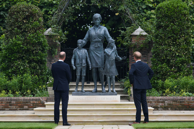 Pangeran William dan Pangeran Harry melihat patung Putri Diana saat peresmian di Taman Sunken, Istana Kensington, London, Inggris. Foto: Dominic Lipinski/Pool/REUTERS