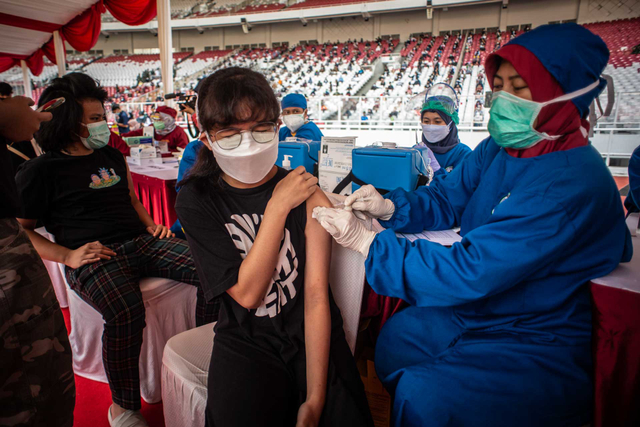 Petugas medis menyuntikan vaksin COVID-19 ke pada warga saat vaksinasi COVID-19 massal di Stadion Utama Gelora Bung Karno, Senayan, Jakarta, Sabtu (3/7/2021). Foto: Aprillio Akbar/ANTARA FOTO