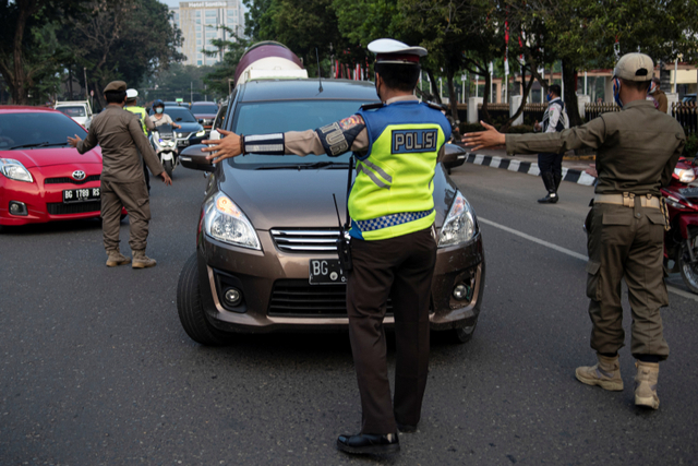 Petugas gabungan dari Polri, Sat Pol PP dan Dinas Perhubungan (Dishub) mengatur lalu lintas saat penerapan aturan ganjil genap di jalan POM IX, Palembang, Sumatera Selatan, Senin (5/7). Foto: Nova Wahyudi/ANTARA FOTO