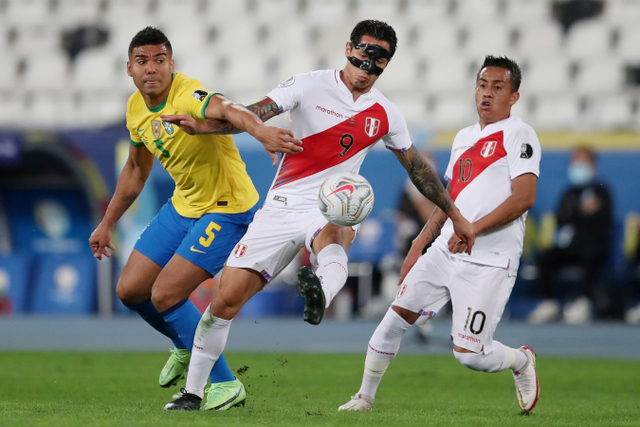 Pemain Brasil Casemiro berebut bola dengan pemain Peru Gianluca Lapadula pada pertandingan semi final Copa America 2021 di Estadio Nilton Santos, Rio de Janeiro, Brasil.
 Foto: Ricardo Moraes/REUTERS