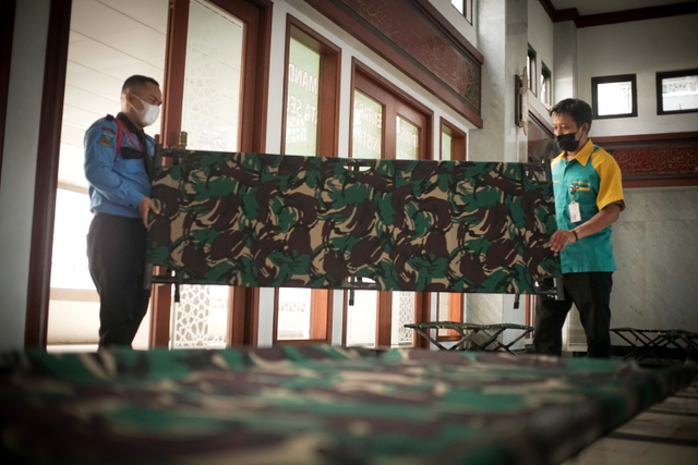 Petugas menyiapkan tempat tidur untuk warga yang akan menjalani isolasi mandiri di Kantor Wali Kota Jakarta Selatan. Foto: Iqbal Firdaus/kumparan