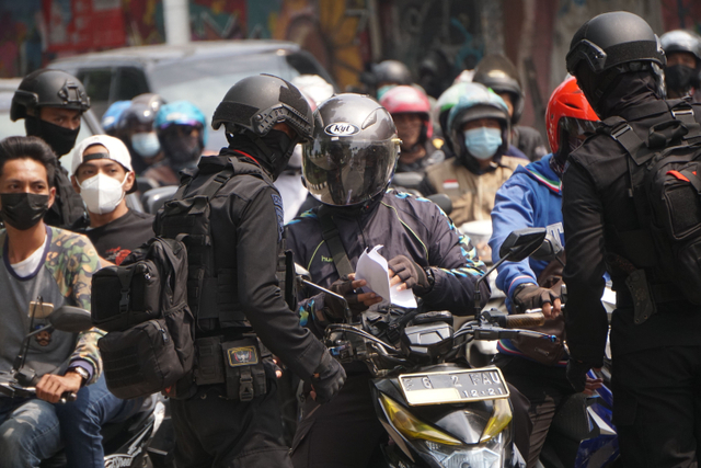 Polisi mengecek surat di pos penyekatan PPKM Darurat di Lenteng Agung, Jakarta Selatan, Selasa (6/7/2021). Foto: Jamal Ramadhan/kumparan