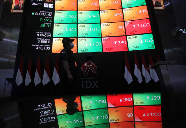 Karyawan melintas di dekat layar monitor pergerakan Indeks Harga Saham Gabungan (IHSG) di Bursa Efek Indonesia. Foto: ANTARA FOTO/Reno Esnir