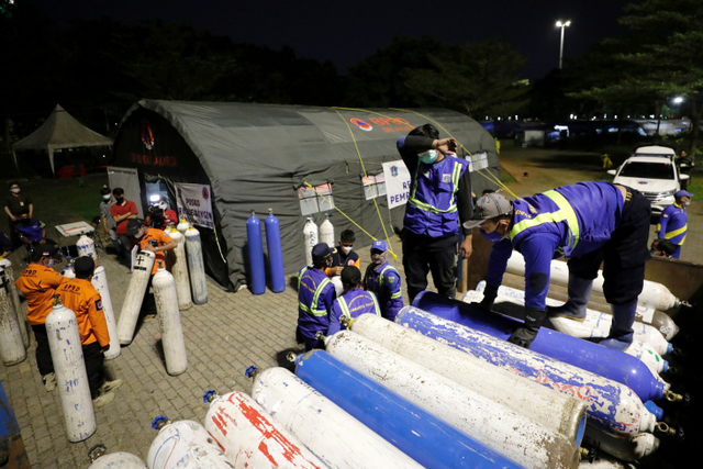 Petugas Sumber Daya Air (SDA) menyiapkan tabung oksigen gratis di Oxygen Rescue Monas untuk rumah sakit. Foto: Willy Kurniawan/Reuters