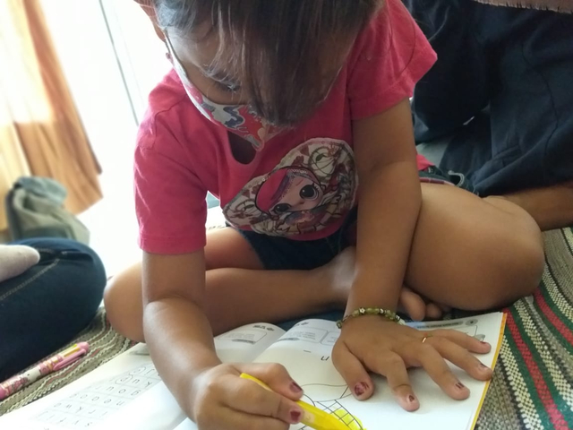 Seorang siswa sedang mengerjakan tugas