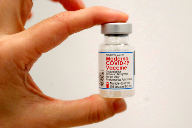 Seorang petugas kesehatan memegang botol Vaksin Moderna COVID-19. Foto: REUTERS/Mike Segar