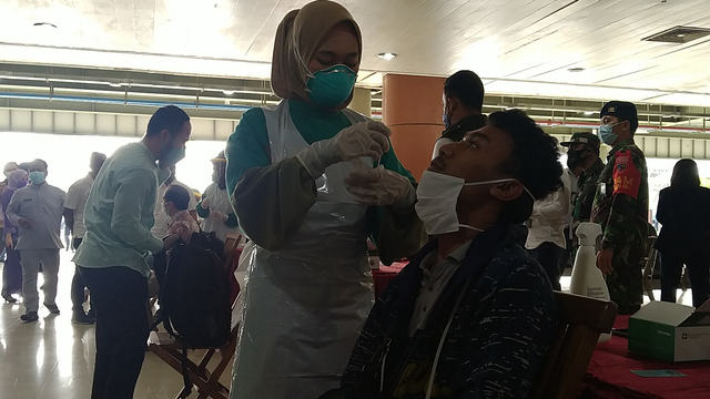 PETUGAS kesehatan mengambil sampel di hidung penumpang pesawat yang baru mendarat di Bandar Udara Sultan Syarif Kasim (SSK) II, Pekanbaru.        