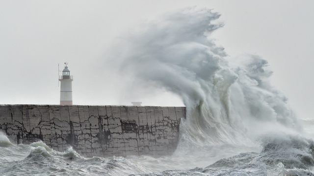Ombak menghantam tembok pelabuhan Newhaven di pantai selatan Inggris. Foto: Glyn Kirk / AFP
