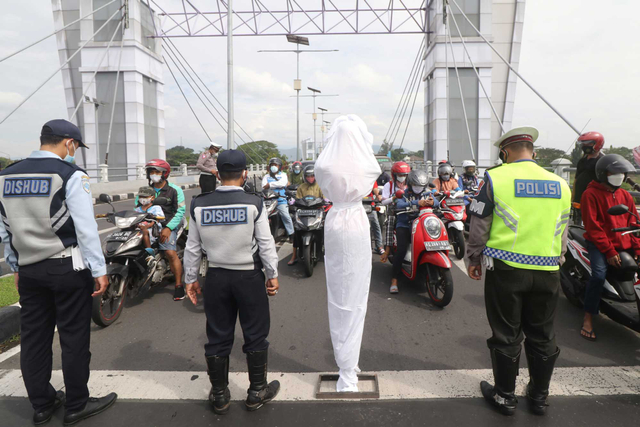 Anggota Satlantas Polres Kediri Kota bersama Dinas Perhubungan mengajak pengguna jalan untuk mengheningkan cipta bagi korban COVID-19 di Kota Kediri, Jawa Timur, Sabtu (10/7/2021). Foto: Prasetia Fauzani/ANTARA FOTO