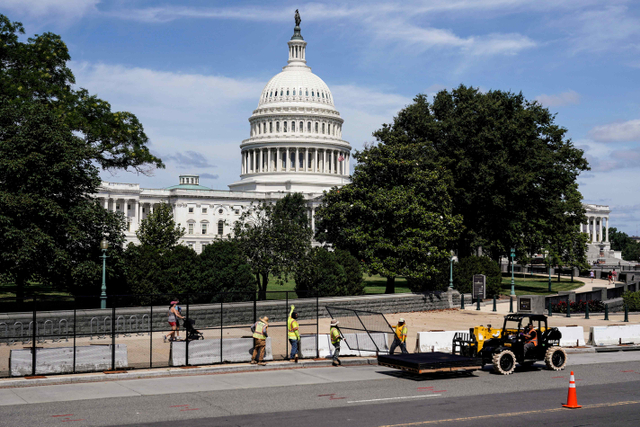 Pekerja mencopot pagar keamanan setelah serangan 6 Januari di Gedung Capitol di Washington, Amerika Serikat. Foto: Joshua Roberts/Reuters