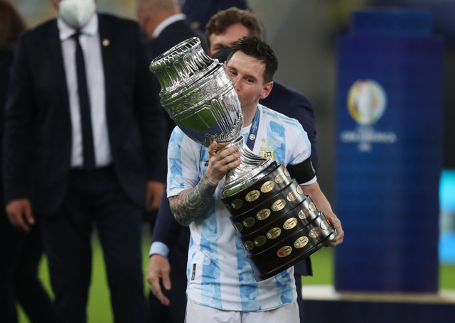 Pemain Argentina Lionel Messi mencium trofi Copa America 2021 mengalahkan Brasil di Estadio Maracana, Rio de Janeiro, Brasil. Foto: Ricardo Moraes/REUTERS