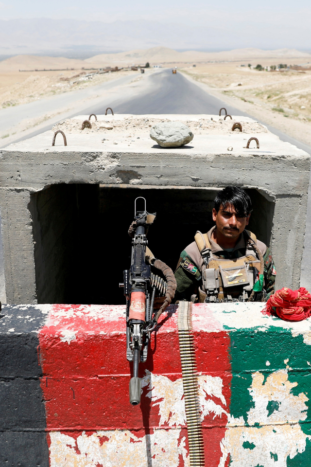 Seorang tentara Tentara Nasional Afghanistan berjaga di sebuah pos pemeriksaan dekat Pangkalan Udara Bagram, di provinsi Parwan, Afghanistan. Foto: Mohammad Ismail/REUTERS