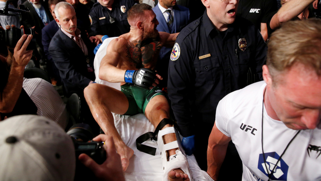 Conor McGregor ditandu setelah pertarungan di UFC 264, T-Mobile Arena, Las Vegas, Amerika Serikat, Sabtu (10/7). Foto: Steve Marcus/REUTERS