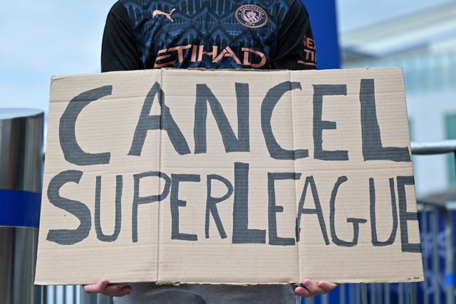Fans Manchester City memegang poster penolakan European Super League di di Stamford Bridge, London, Inggris. Foto: JUSTIN TALLIS / AFP