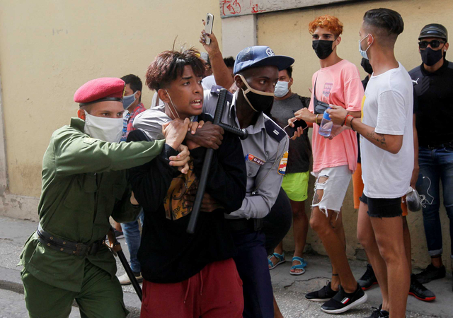 Polisi menangkap demonstran saat protes menentang pemerintah di tengah wabah COVID-19, di Havana, Kuba, Minggu (11/7). Foto: Stringer/Reuters