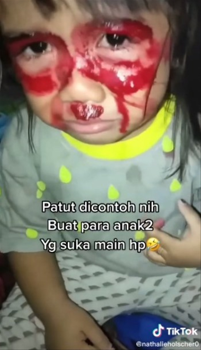 Momen kocak seorang bocah perempuan dikerjain ibunya dengan mengolesi mata anaknya pakai lipstik karena kecanduan main HP. (Foto: TikTok/@nathalieholscher0)