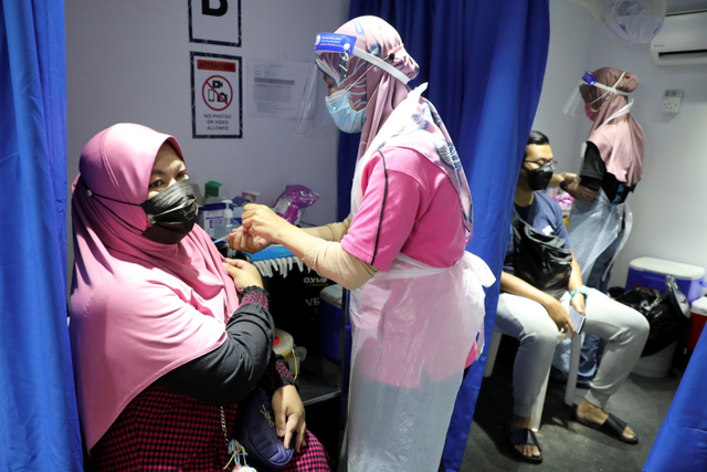 Petugas memberikan vaksin corona Sinovac kepada warga di di Kuala Lumpur, Malaysia. Foto: Lim Huey Teng/REUTERS