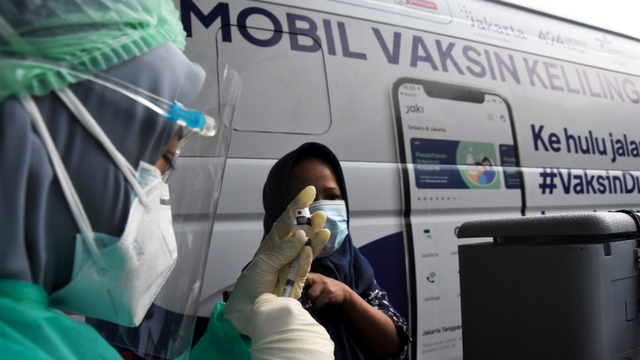 Petugas kesehatan menyuntikkan vaksin Sinovac kepada warga saat mobil vaksin keliling singgah di Kantor Kelurahan Cipedak, Jakarta, Selasa (13/7/2021). Foto: Indrianto Eko Suwarso/ANTARA FOTO