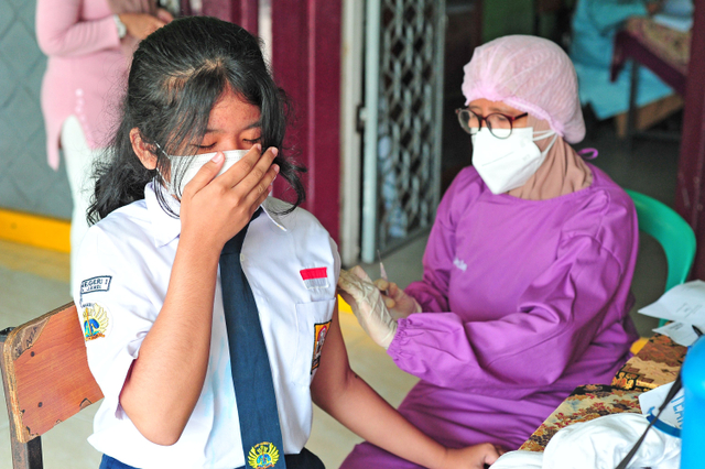 Pelajar SMPN 1 Kota Jambi menerima suntikan vaksin COVID-19 dosis pertama dari tenaga kesehatan di Jambi, Senin (12/7).  Foto: Wahdi Septiawan/ANTARA FOTO