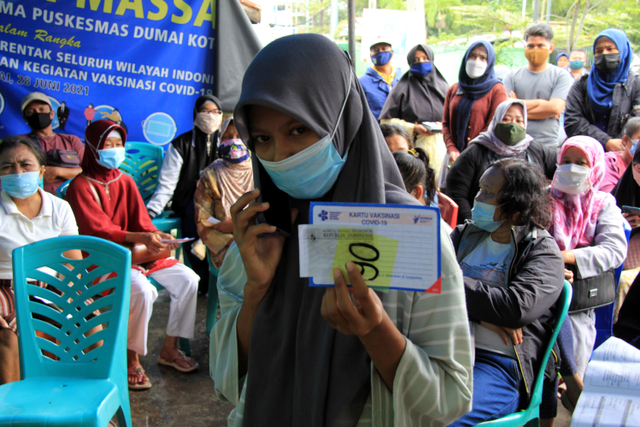Seorang pelajar memperlihatkan kartu peserta penerima vaksin COVID-19 di Puskesmas Dumai Kota, Dumai, Riau, Selasa (13/7).  Foto: Aswaddy Hamid/ANTARA FOTO