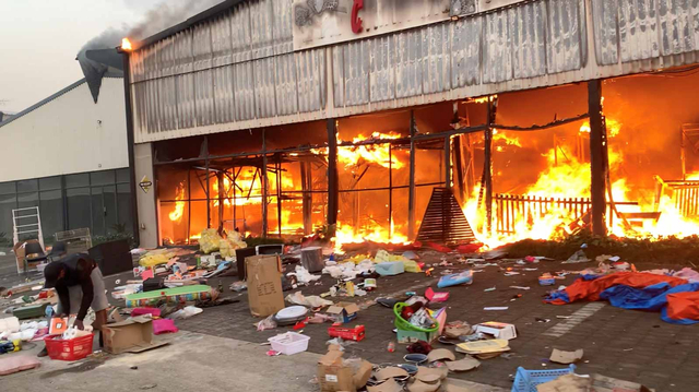 Kebakaran melanda Campsdrift Park, yang menampung Makro dan China Mall, menyusul protes yang meluas menjadi penjarahan di Pietermaritzburg, Afrika Selatan 13 Juli 2021. Foto:  Sibonelo Zungu/via REUTERS