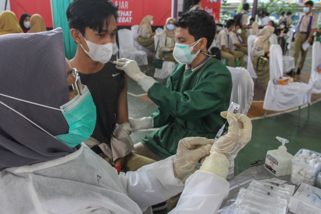 Vaksinator bersiap untuk menyuntikkan vaksin COVID-19 kepada pelajar di SMAN 1 Kota Pekanbaru, Riau, Rabu (14/7).  Foto: Rony Muharrman/ANTARA FOTO