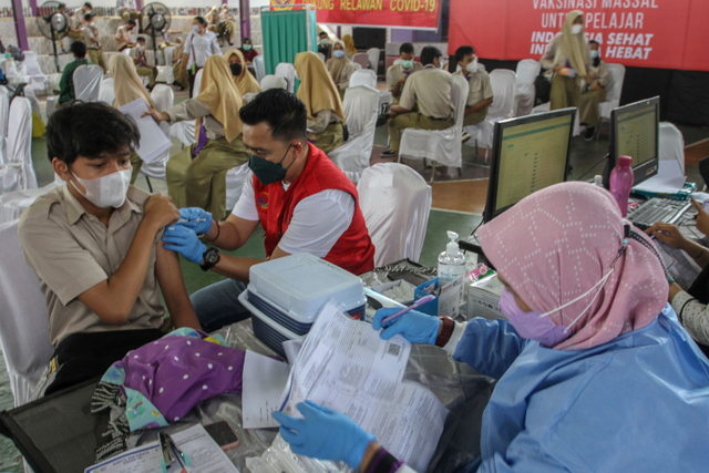 Vaksinator menyuntikkan vaksin COVID-19 kepada pelajar di SMAN 1 Kota Pekanbaru, Riau, Rabu (14/7).  Foto: Rony Muharrman/ANTARA FOTO