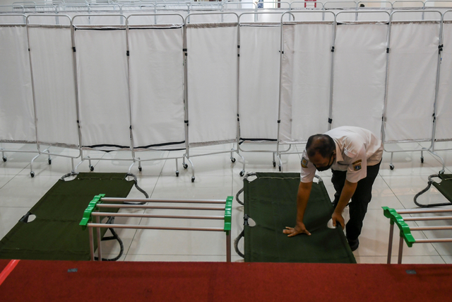 Petugas menyiapkan tempat isolasi pasien COVID-19 di Gelanggang Olahraga (GOR) Matraman, Jakarta, Rabu (14/7). Foto: Galih Pradipta/Antara Foto