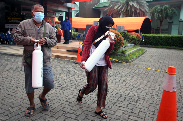 Warga membawa tabung oksigen usai melakukan pengisian ulang tabung oksigen ukuran satu meter kubik di kawasan Puspemkot Tangerang, Tangerang, Banten, Rabu (14/7/2021). Foto: Muhammad Iqbal/ANTARA FOTO