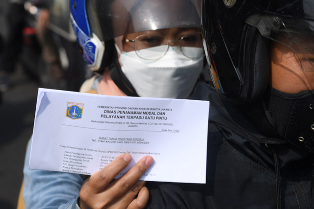 Warga menunjukkan dokumen saat melintasi titik penyekatan baru di Mampang, Jakarta, Kamis (15/7). Foto: Akbar Nugroho Gumay/ANTARA FOTO