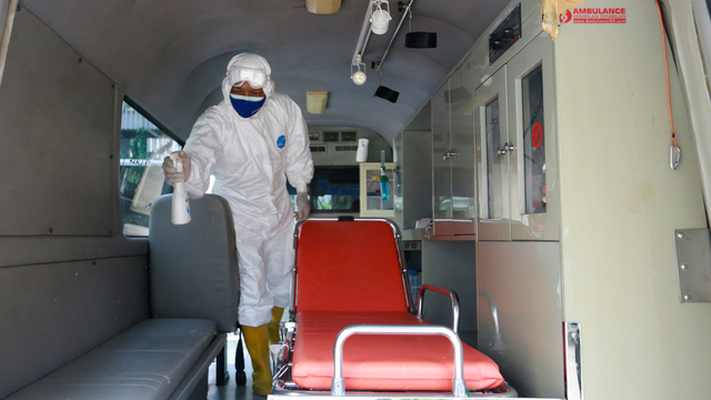 Pengemudi ambulans Sunaryo menyemprotkan disinfektan usai mengantarkan pasien COVID-19 di sebuah rumah sakit, di pinggiran Jakarta, Selasa (13/7). Foto: Ajeng Dinar Ulfiana/REUTERS