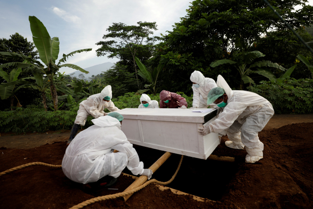 Petugas memakamkan jenazah dengan protokol COVID-19 di Bogor, Jawa Barat.  Foto: Willy Kurniawan/REUTERS