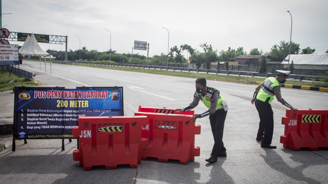Polisi memasang barier saat melakukan penyekatan kendaraan yang akan masuk tol melalui Gerbang Tol Colomadu di Karanganyar, Jawa Tengah, Jumat (16/7/2021). Foto: Mohammad Ayudha/ANTARA FOTO