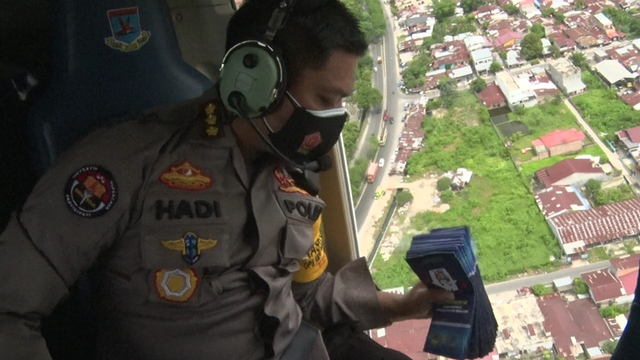 Polda Sumut saat membagikan brosur taat Prokes melaui helikopter. Foto: Dok. Istimewa