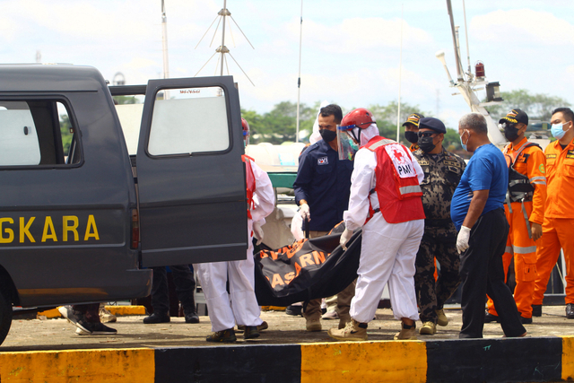 Sejumlah petugas membawa satu kantung jenazah awak kapal yang berhasil ditemukan SAR ke dalam ambulans di dermaga Kesatuan Penjagaan Laut dan Pantai (KPLP) di Pontianak. Foto: Jessica Helena Wuysang/Antara Foto