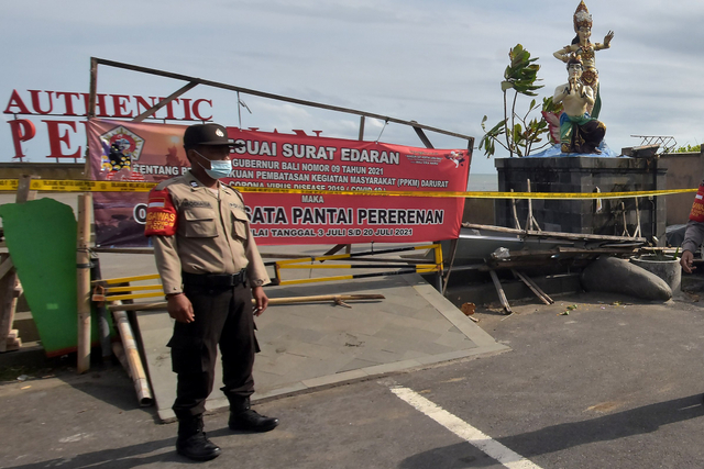 Polisi menjaga area Pantai Pererenan, Badung, Bali, Sabtu (17/7/2021). Foto: Nyoman Hendra Wibowo/Antara Foto