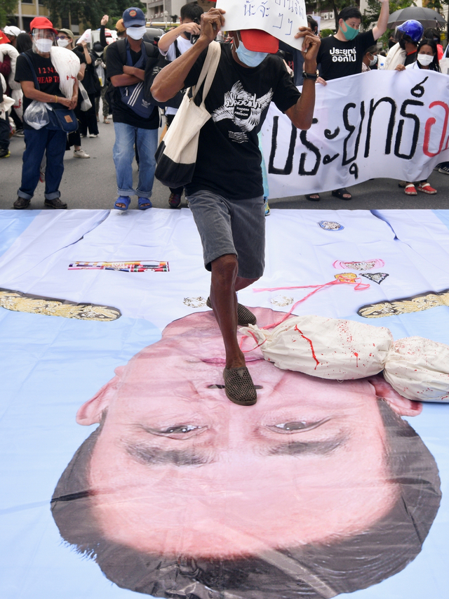 Seorang pengunjuk rasa anti-pemerintah menginjak gambar Perdana Menteri Thailand Prayuth Chan-ocha saat protes di Bangkok, Thailand, Minggu (18/7). Foto: Chalinee Thirasupa/REUTERS