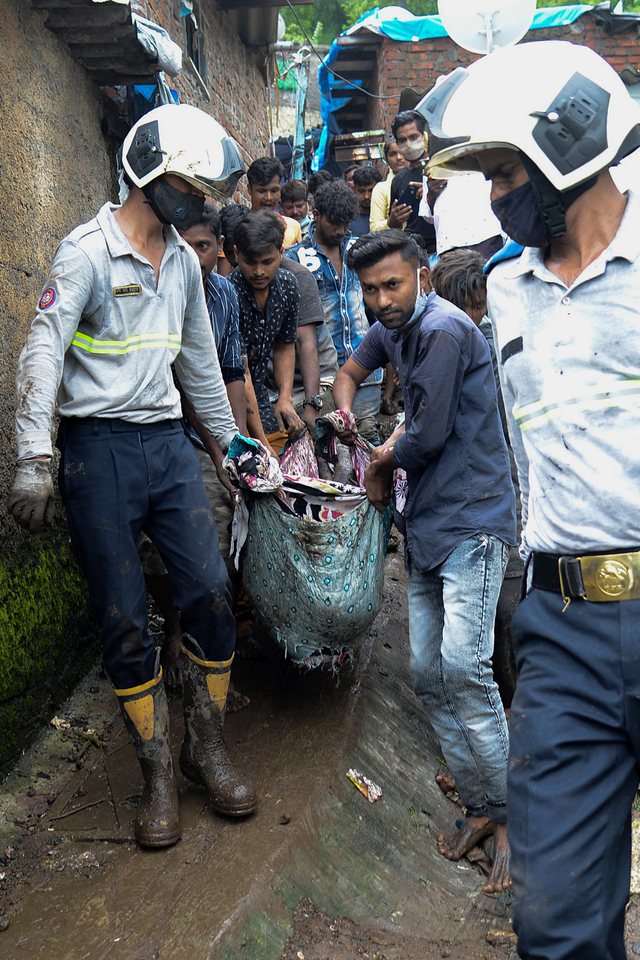 Petugas penyelamat dan warga mengevakuasi korban longsor di Mumbai, India. Foto: Sujit Jaiswal / AFP
