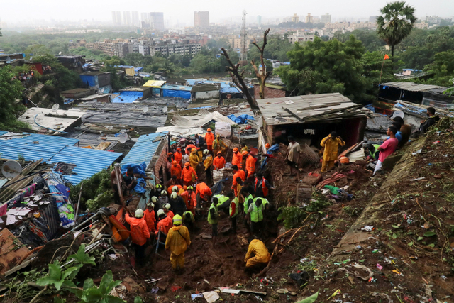 Petugas penyelamat membersihkan puing-puing saat mencari korban tanah longsor di Mumbai, India. Foto: Niharika Kulkarni/REUTERS
