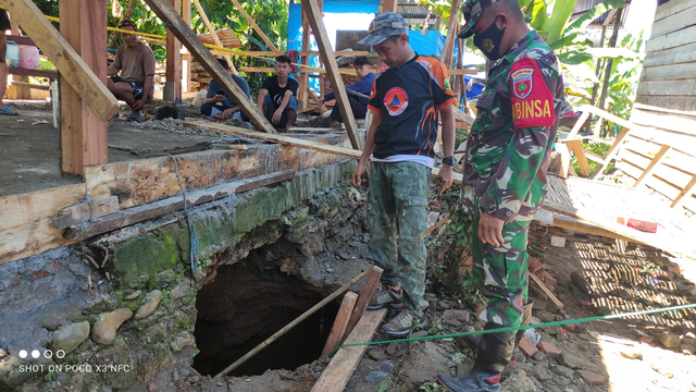Personel Kodim 1418 Mamuju dan petugas BPBD Mamuju memeriksa lubang tanah yang muncul di rumah salah satu warga di Desa Takandeang. Foto: Dok. Istimewa/SulbarKini