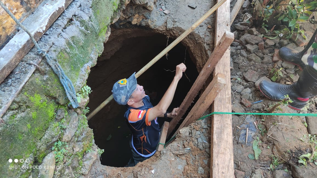 Petugas BPBD Mamuju memeriksa lubang tanah yang muncul di rumah salah satu warga di Desa Takandeang. Foto: Dok. Istimewa/SulbarKini