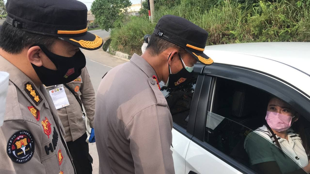 Kapolres Tanjungpinang sedang bertanya kepada seorang pengemudi yang akan melewati pos PPKM Darurat Kota Tanjungpinang. (Foto: Yude/Batamnews)