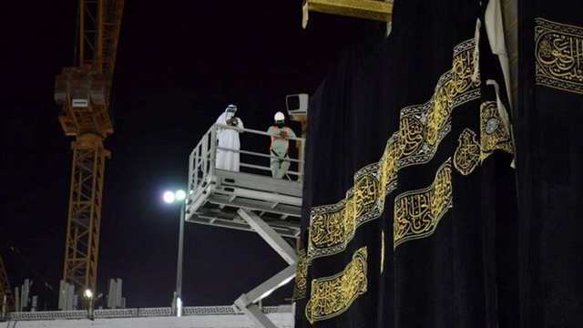 Petugas mengganti kain penutup Ka'bah (Kiswa) yang baru pada musim haji 2021 di kota suci Mekah, Arab Saudi, 18 Juli 2021. Foto: Saudi Press Agency via Reuters