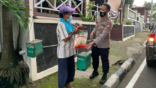 Kapolres Ternate memberikan beras kepada masyarakat kurang mampu yang taat prokes. Foto: Istimewa