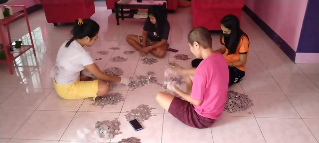 Para pemudi gereka saat menggihung koin hasil pengumpulan untuk beli oksigen bantu warga Batang Dua. Foto: Facebook Keegan Lapulalan.