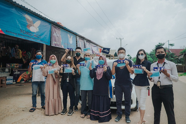 Rahmad dan Verdiawaty, pemilik Toko Aci, berfoto bersama tim Aice ketika penyerahan hadiah mobil. Foto: Aice.
