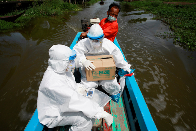 Petugas kesehatan Thailand melakukan perjalanan menggunakan perahu untuk melakukan tes swab kepada warga yang tinggal di komunitas terpencil di Samut Prakan, Thailand. Foto: Soe Zeya Tun/REUTERS