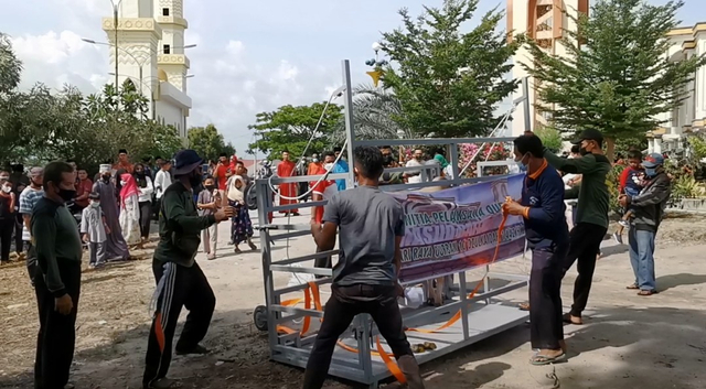 Panitia kurban menggunakan besi kerangkeng untuk merobohkan hewan kurban yang akan disembelih. Foto: Khairul S/kepripedia.com