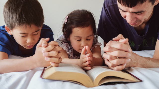 Ilustrasi anak berdaoa bersama alkitab kristen. Foto: Shutter Stock