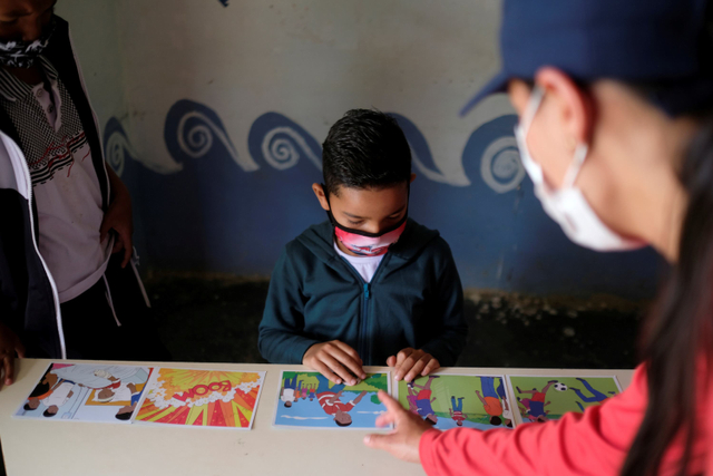 Anggota badan amal pembersihan ranjau darat internasional HALO Trust mengajari seorang anak cara mengidentifikasi ranjau anti-personil di Carmen de Viboral, Kolombia. Foto: Santiago Mesa/REUTERS